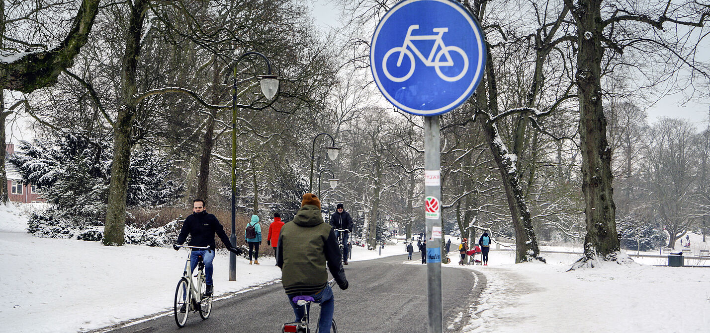 Winterlicher Fahrradweg in Groningen Radfahrer auf geräumten Radweg in Groningen