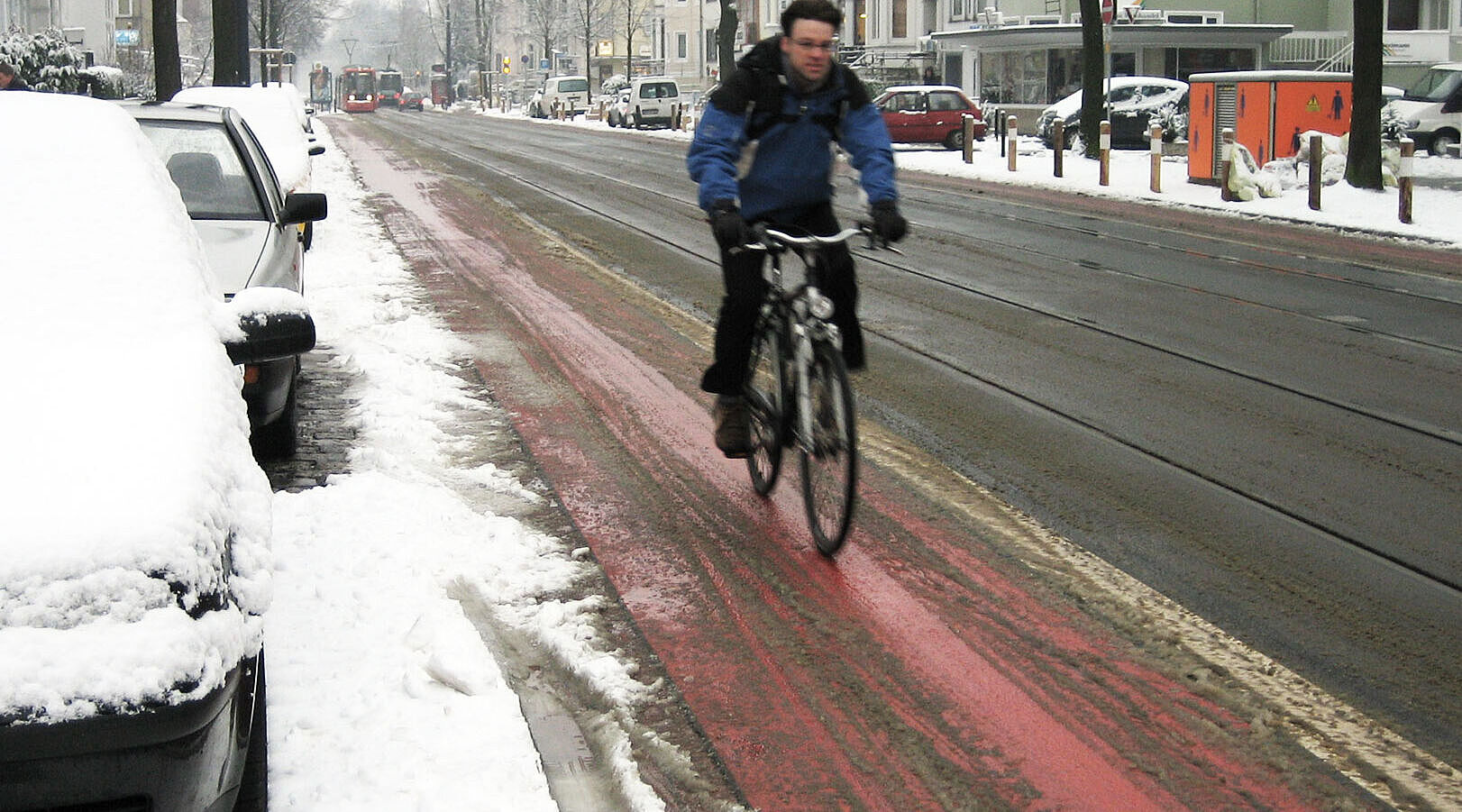 Ein leicht verschneiter Radweg.